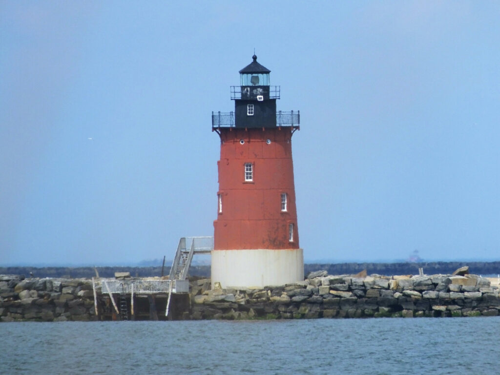 The red Breakwater Lighthouse standing tall in the shores of Cape Henlopen State Park.