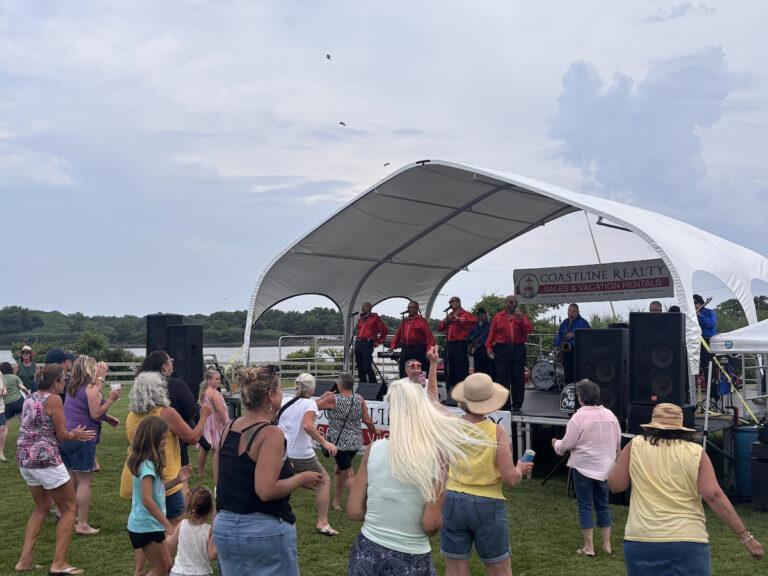 Crowd gathers around the performers' tent (4 singers in red)