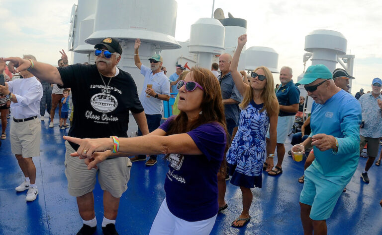 A lady in a purple shirt dances in the crowd during Rock the Boat