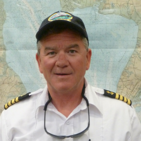 Head shot of Captain David Brown in uniform along with a black Cape May - Lewes Ferry cap