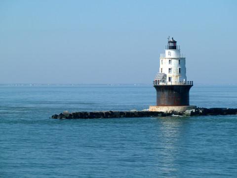 Harbor of Refuge Lighthouse casting its shadows over the blue waters of the Delaware Bay