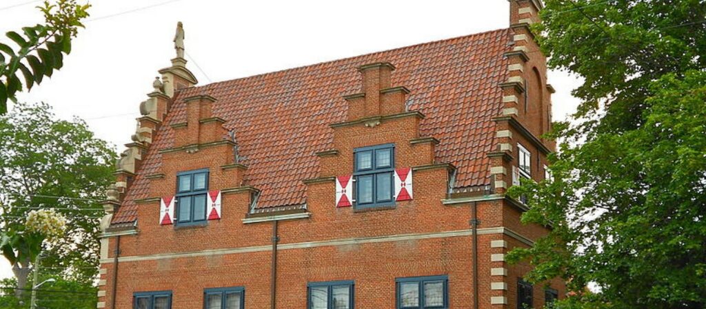 Historic Dutch-style brick building with a red stepped gable roof and blue window frames, representing the history or architecture of Lewes or Cape May.