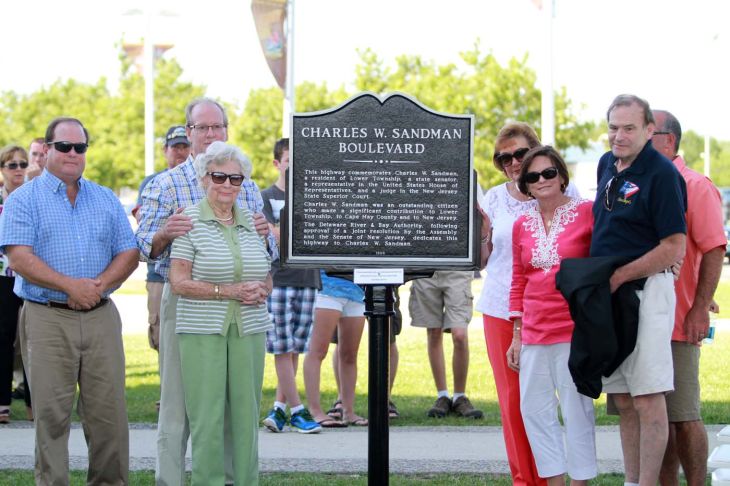 Congregation poses in front of Charles W. Sandman Boulevard dedication sign